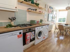 A kitchen with appliances and dining area at Mallow Cottage in Langton Matravers