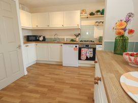 A kitchen with cabinets and appliances at Mallow Cottage in Langton Matravers