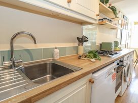 A kitchen with a sink and gas stove at Mallow Cottage in Langton Matravers