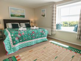 A bedroom with a bed and large window at Mallow Cottage in Langton Matravers