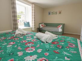 A bedroom with a bed and a sofa at Mallow Cottage in Langton Matravers