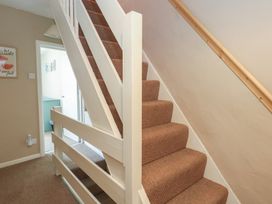 A staircase with carpet and handrail at Mallow Cottage in Langton Matravers