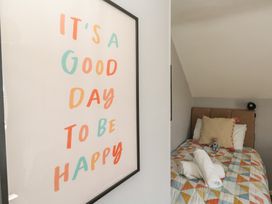 A bedroom with a bed and a framed picture at Mallow Cottage in Langton Matravers