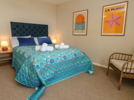 A bedroom with a bed and wall art at Mallow Cottage in Langton Matravers