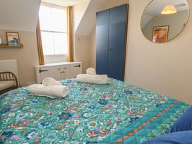 A bedroom with a bed and window at Mallow Cottage in Langton Matravers