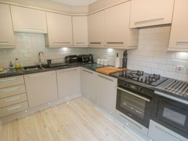 A kitchen with cabinets, a sink, a stove, and appliances at The Shipwrights in Whitby