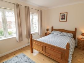 A bedroom with a wooden bed and windows at The Shipwrights in Whitby
