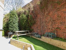 A garden with a wooden bench and grill at The Shipwrights in Whitby