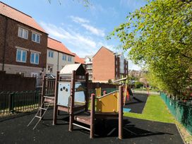 A playground with various equipment and apartment buildings at The Shipwrights in Whitby