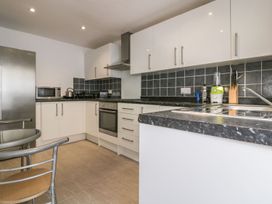 A kitchen with appliances and furniture at Chy Vean in St. Agnes