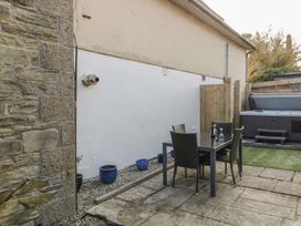 A garden with a dining set and hot tub at Chy Vean in St. Agnes