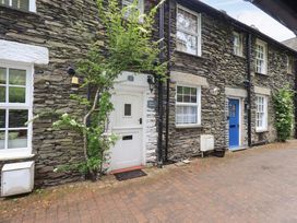 An outdoor view of Stoker’s Cottage featuring stone walls and doors in Windermere