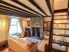 A living room with a fireplace and sofa at Stoker’s Cottage in Windermere