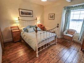 A bedroom with a bed and nightstands at Stoker’s Cottage in Windermere