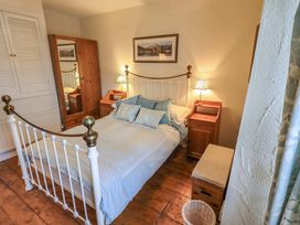 A bedroom with a bed and wardrobe at Stoker’s Cottage in Windermere