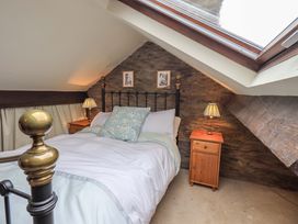 A bedroom with a bed and nightstand at Stoker’s Cottage Windermere