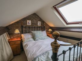 A bedroom with a bed and side tables at Stoker’s Cottage Windermere