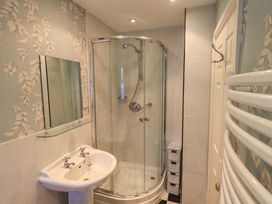 A bathroom with shower and sink at Stoker’s Cottage, Windermere