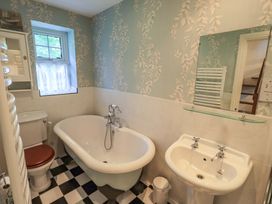 A bathroom featuring a bathtub, sink, and toilet at Stoker’s Cottage in Windermere