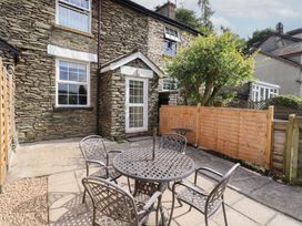 A garden with a table and chairs at Stoker’s Cottage in Bowness-On-Windermere