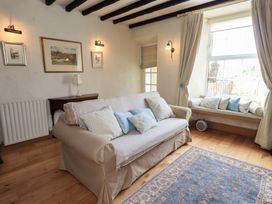 A living room with a sofa and table at Stoker’s Cottage in Bowness-On-Windermere