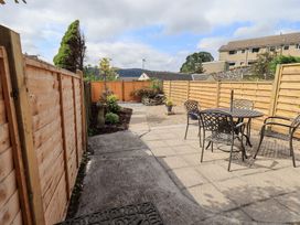 A garden with a table and chairs at Stoker’s Cottage in Bowness-On-Windermere