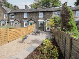 A garden with a table and chairs in Stoker’s Cottage in Bowness-On-Windermere