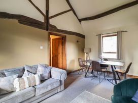 A living room with a sofa, table, and chairs at Idris Barn Dolgellau