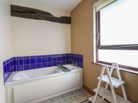 A bathroom with a bathtub and window at Idris Barn Dolgellau