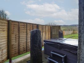 An outdoor space featuring a hot tub and wooden fencing at Idris Barn Dolgellau