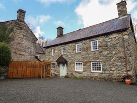 A stone house with a fence in an outdoor area at Cader Cottage Dolgellau
