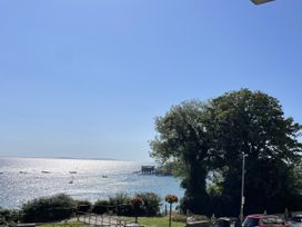 A view of the sea with boats and trees at 10 Croft Court in Tenby