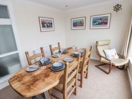 A dining room with a wooden table and chairs at Lifeboat Lookout in Tenby