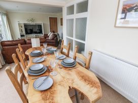 A dining room with a wooden table set for dinner at Lifeboat Lookout in Tenby