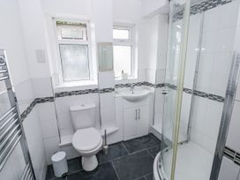 A bathroom with a shower enclosure and sink at Lifeboat Lookout in Tenby