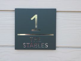 A sign displaying number 1 and the text THE STABLES at 1 The Stables Highbridge