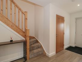 A hallway with a staircase and console table at 1 The Stables in Highbridge