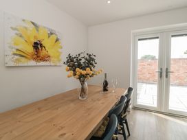A dining room with a wooden table and chairs at 1 The Stables in Highbridge