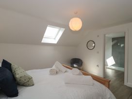 A bedroom with a bed and chair at 1 The Stables in Highbridge