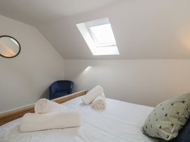 A bedroom with a bed and a chair at 1 The Stables Highbridge