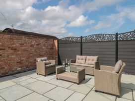 An outdoor seating area with furniture and a brick wall at 1 The Stables Highbridge