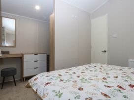A bedroom with a bed and a dresser at Woodland Way in Benllech