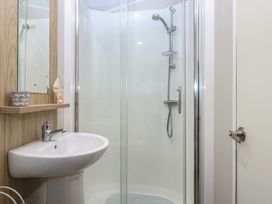 A bathroom with a shower and a basin at Woodland Way in Benllech
