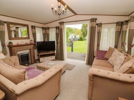 A living room with a sofa and television at 22 Yealand in Carnforth