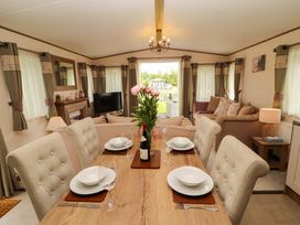 A dining table with chairs and flowers at 22 Yealand in Carnforth