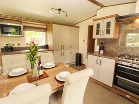 A kitchen with a dining area and modern appliances at 22 Yealand in Carnforth