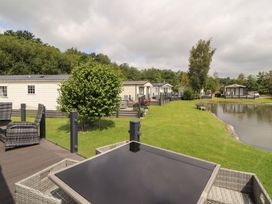 An outdoor view of holiday homes by a lake at 22 Yealand in Carnforth