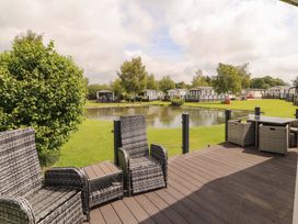 An outdoor seating area overlooking a pond at 22 Yealand in Carnforth