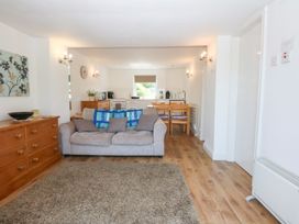 A living room with a sofa and dining area at Hafan Bach in Abersoch