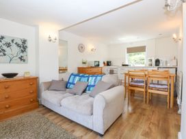 A living room with a sofa and dining table at Hafan Bach in Abersoch